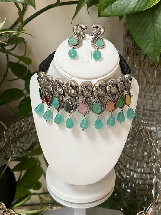 Meta keywords: German silver necklace, heavy necklace, semi-precious stones, pastel colors, elegant birds, parrot-shaped earrings, high-quality jewelry, statement jewelry, fashion jewelry, Indian traditional jewelry, bridal jewelry.